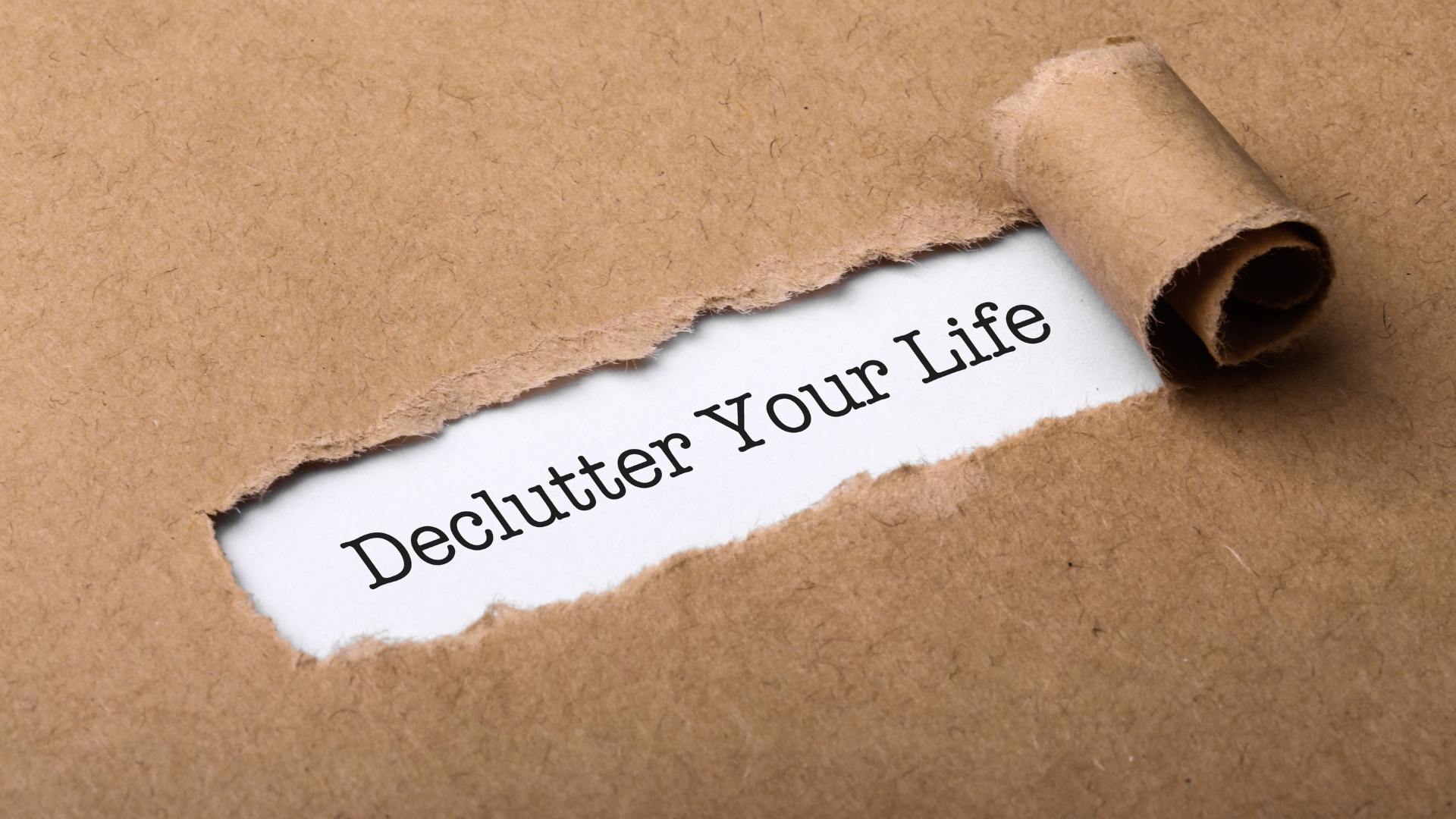 Cardboard ripped to reveal 'Declutter your life' in black text on white paper